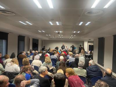 La sala repleta de asistentes y al fondo el concierto.
