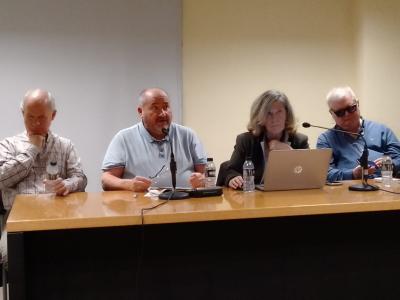 En la foto una mesa con 4 ponentes, 3 hombres y una mujer. 