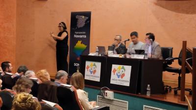 En el salón de actos de la ONCE en la mesa está Ángel Sánchez, Ramón Estévez y Alfredo Borja con la intérprete en lengua de signos al fondo.