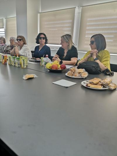 Reunión de la Comisión de Sección de Seniors de la ONCE en Sevilla. En la sesión participan, entre otros compañeros, Isabel Viruet, Mercedes de Luna y Loli Carmen Polo. Sobre la mesa se observan documentos, zumos, fruta y aperitivos, denotándoes un ambiente de trabajo ameno y  participativo.