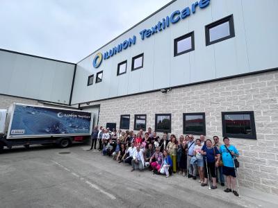 IMAGEN DEL GRUPO DE UP GIJÓN A LA ENTRADA DE ILUNION TEXTIL CARE CON SUS RESPONSABLES