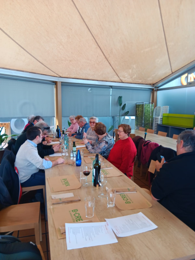 Fotografía en la que se muestra el grupo de asistentes a la comida conversando entre ellos. 
