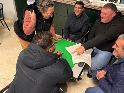 La imagen corresponde a una sesión de los cursos de formación de la agrupación de Unidad Progresista de Sevilla, celebrada en la agencia de Lora. En ella se observa a varios participantes tomando parte activa en una dinámica de grupo, interactuando entre sí en un ambiente participativo y colaborativo. La actividad refleja el compromiso, la implicación y el trabajo en equipo de los asistentes, así como el carácter práctico y participativo de la formación