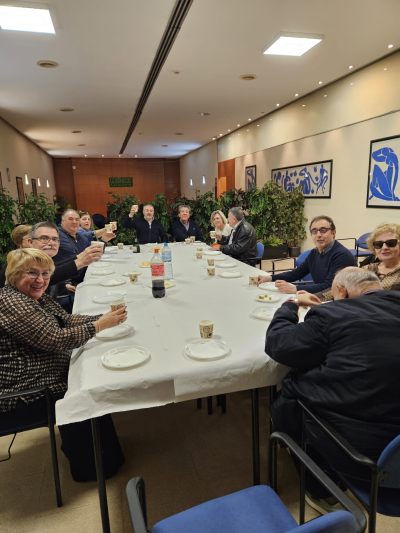Foto en la que se muestra grupo de asistentes de la merienda realizada en Girona, alzando sus copas para brindar.