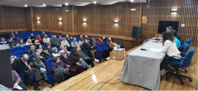 Imagen del salón de actos y de los asistentes a la asamblea.