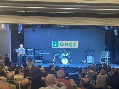 Foto del escenario del salón de actos lleno de instrumento y un patio de butacas con el aforo completo 