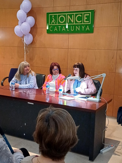 Mesa con la presidenta, secretaria e invitada.