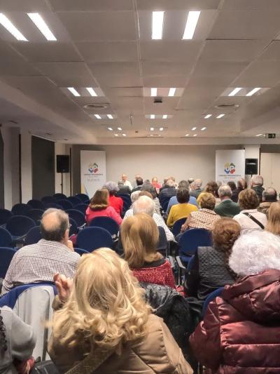Foto desde el fondo de la sala donde se ha celebrado la Asamblea, con un lleno de socios y socias.