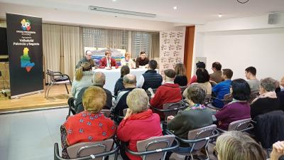 FOTO DE LA CELEBRACION DE LA ASAMBLEA CON LOS ASISTENTES SENTADOS ESCUCHANDO A LA SECRETARIA GENERAL DE LA AGRUPACIÓN