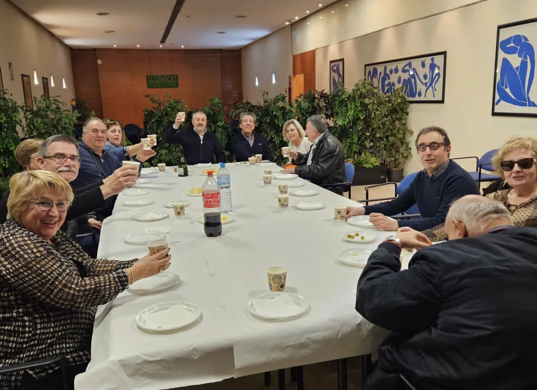 Foto en la que se muestra grupo de asistentes de la merienda realizada en Girona, alzando sus copas para brindar.