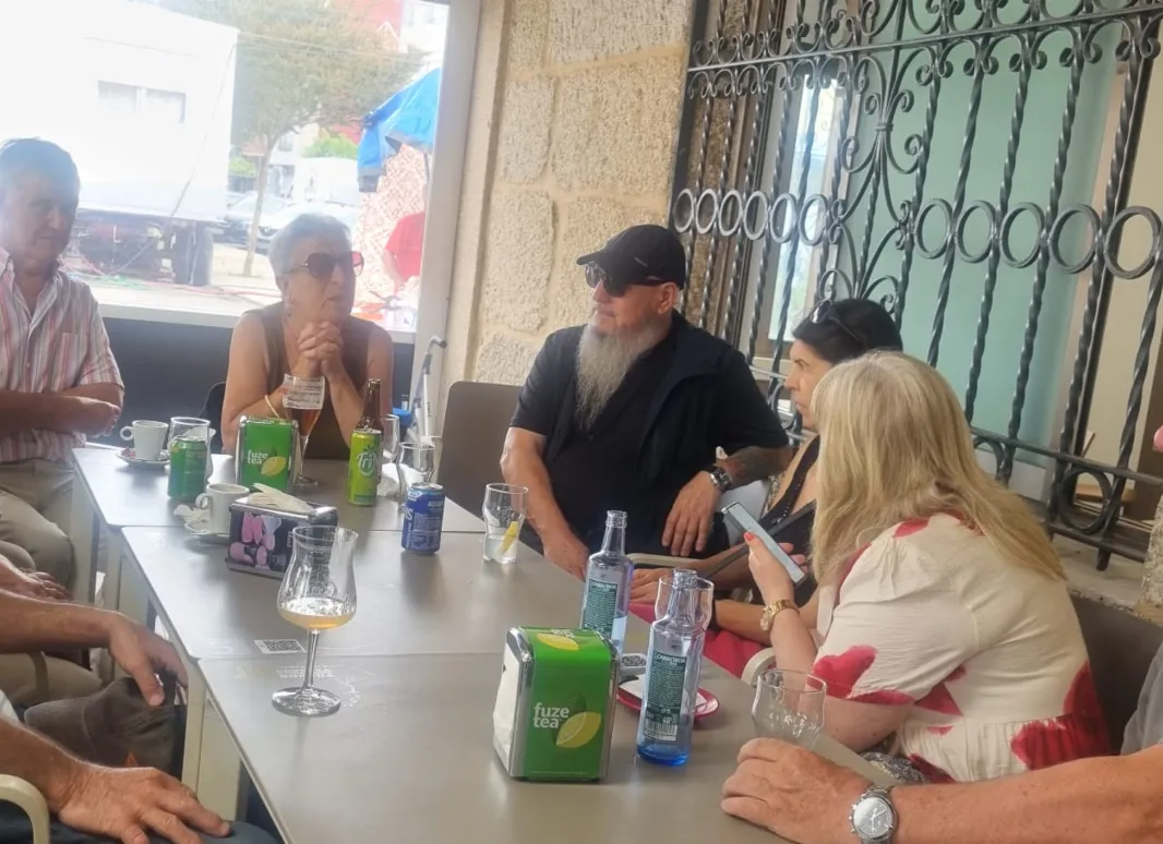 Imagen de grupo alrededor de una mesa en el encuentro con los socios de Moaña.