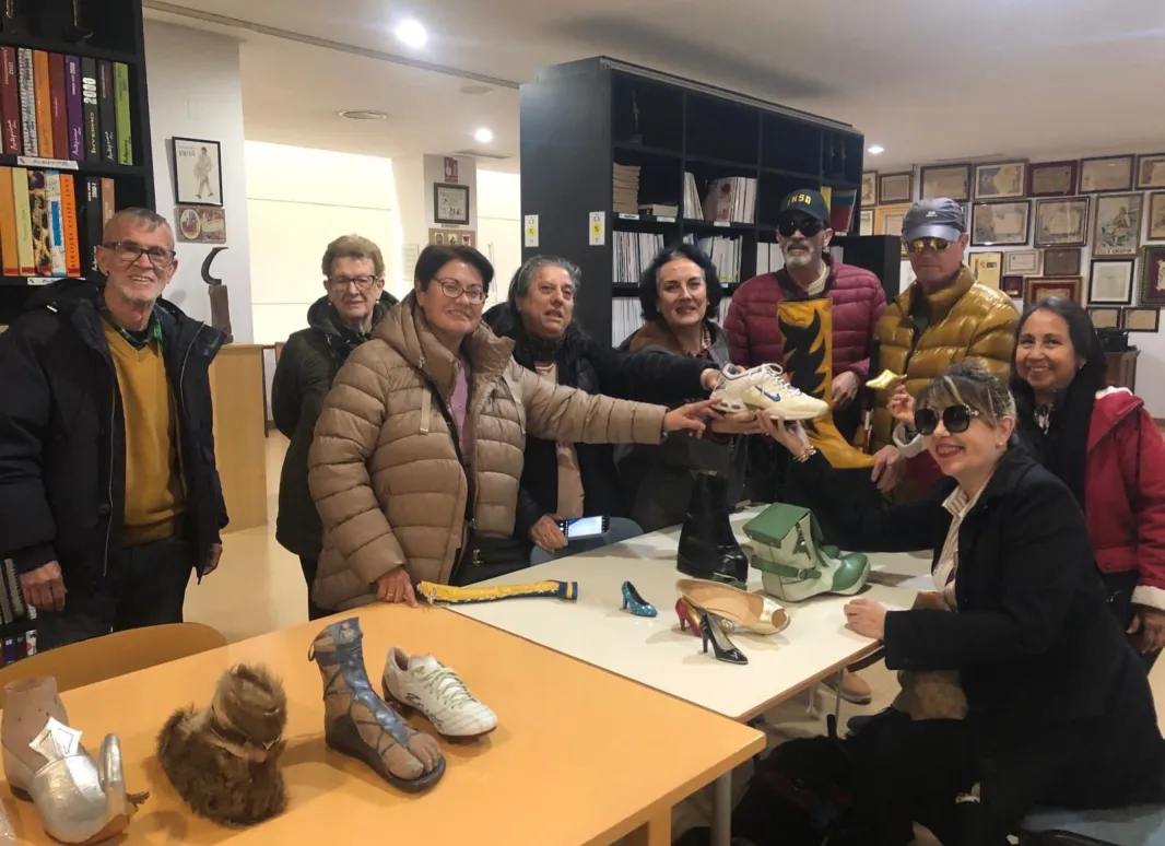 Los asistentes en el museo del calzado cogiendo unos zapatos