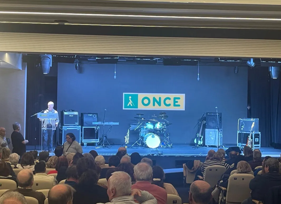 Foto del escenario del salón de actos lleno de instrumento y un patio de butacas con el aforo completo 