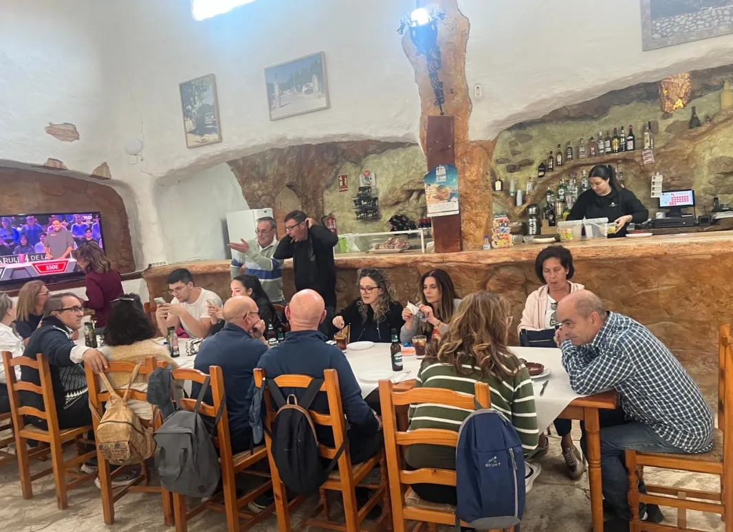 todos los participantes disfrutando de una rica comida alrededor de una mesa.