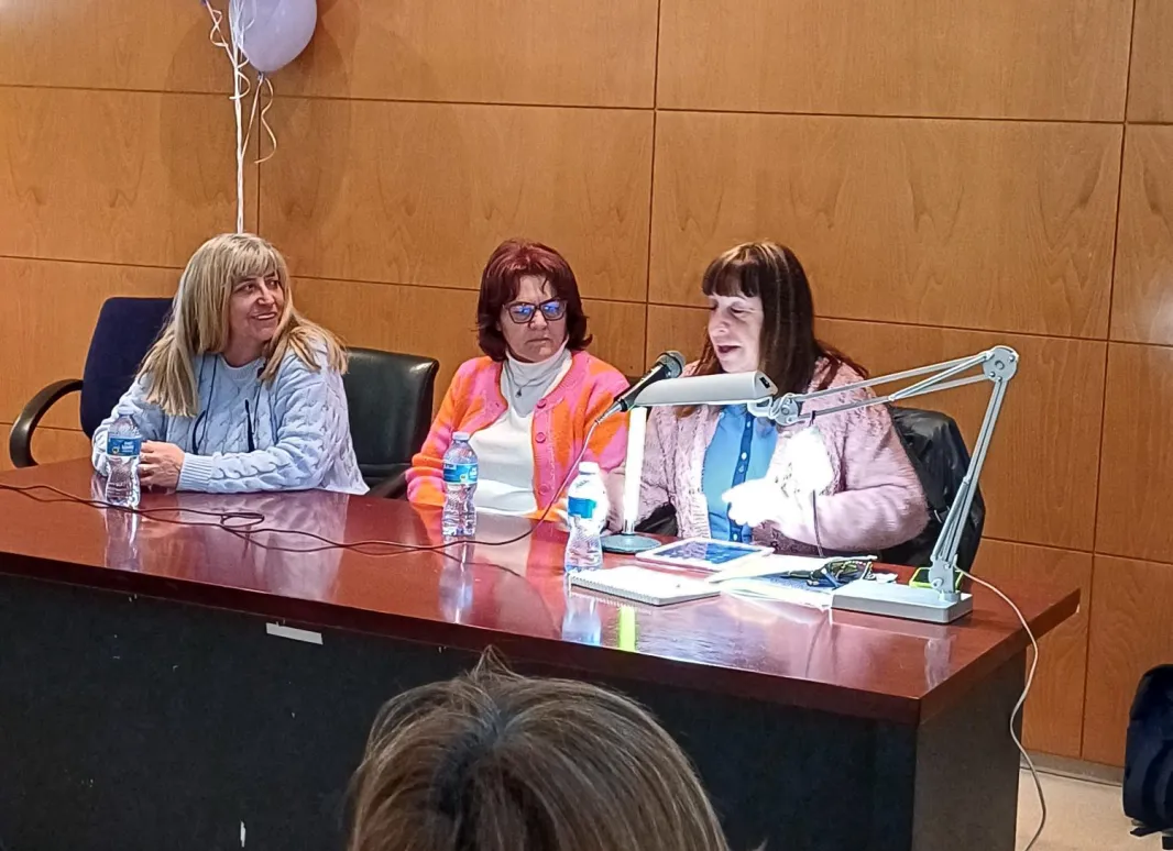 Mesa con la presidenta, secretaria e invitada.