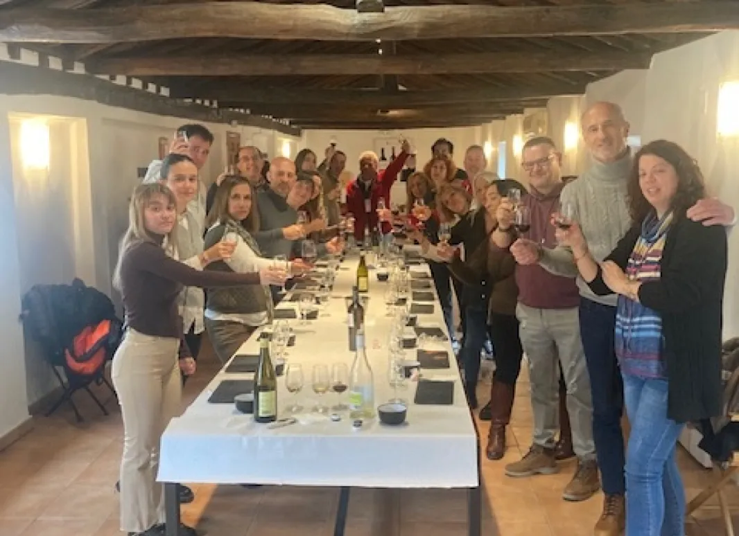GRUPO DE SIMPATIZANTES ALREDEDOR DE UNA GRAN MESA HACIENDO LA CATA DE LOS VINOS