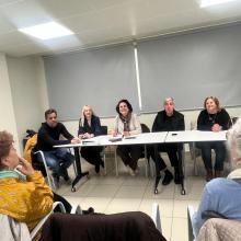 Presidente de SUPO y los 4 secretarios adjuntos sentados en una mesa enfrente de los asistentes