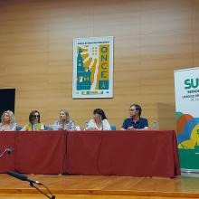 Imagen del escenario donde se desarrolló la Asamblea en la que en el centro se visualiza la mesa con los cinco ponentes quedando a la derecha la enara de SUPO Sevilla