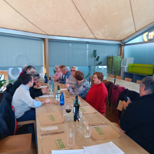 Fotografía en la que se muestra el grupo de asistentes a la comida conversando entre ellos.
