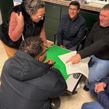 La imagen corresponde a una sesión de los cursos de formación de la agrupación de Unidad Progresista de Sevilla, celebrada en la agencia de Lora. En ella se observa a varios participantes tomando parte activa en una dinámica de grupo, interactuando entre sí en un ambiente participativo y colaborativo. La actividad refleja el compromiso, la implicación y el trabajo en equipo de los asistentes, así como el carácter práctico y participativo de la formación