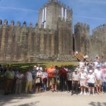 Grupo de participantes de la excursión de SUPO Vigo-Pontevedra posando frente a una fortaleza medieval durante su visita al norte de Portugal.
