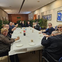 Foto en la que se muestra grupo de asistentes de la merienda realizada en Girona, alzando sus copas para brindar.