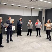 Fotografia en la que aparecen varios participantes, durante el taller de risoterapia en la agencia de la Once en Girona. llevan en la mano un abanico.