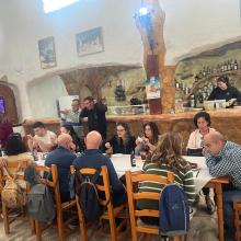 todos los participantes disfrutando de una rica comida alrededor de una mesa.