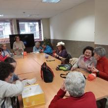 Voluntarias de Asociación ZOES Salamanca, ayudan a tejer a socias de Supo Salamanca-Avila-Zamora en el taller "Punto de encuentro"
